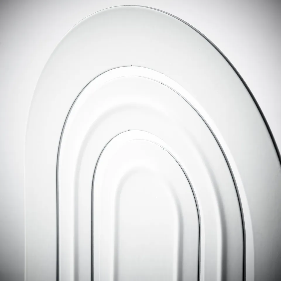 Modern white bookend with three arched slots, made of sturdy epoxy-coated steel.