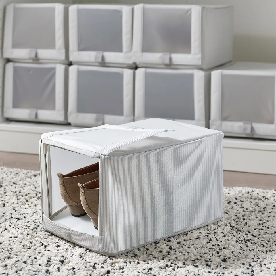 Several HEMMAFIXARE fabric shoe boxes stacked and one open box showing two pairs of shoes and a divider.