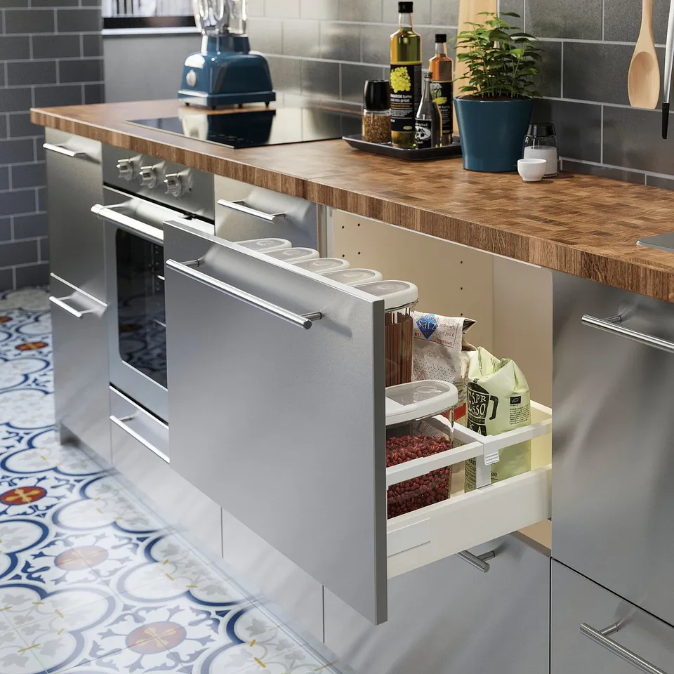 Modern kitchen with stainless-steel appliances, open drawer showing organised food storage.