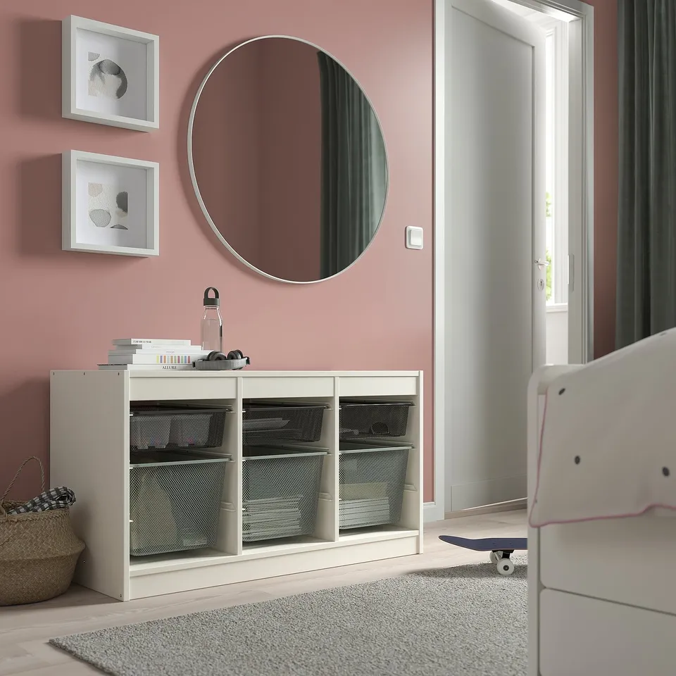 TROFAST storage furniture, 57w, white-cream & mesh, rectangular with drawers. Mirror above, wall art. Skateboard and chair nearby.