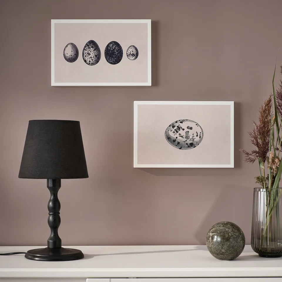 A stylish wall art set, framed and ready to hang or stand, displayed on a shelf with a lamp and vase.