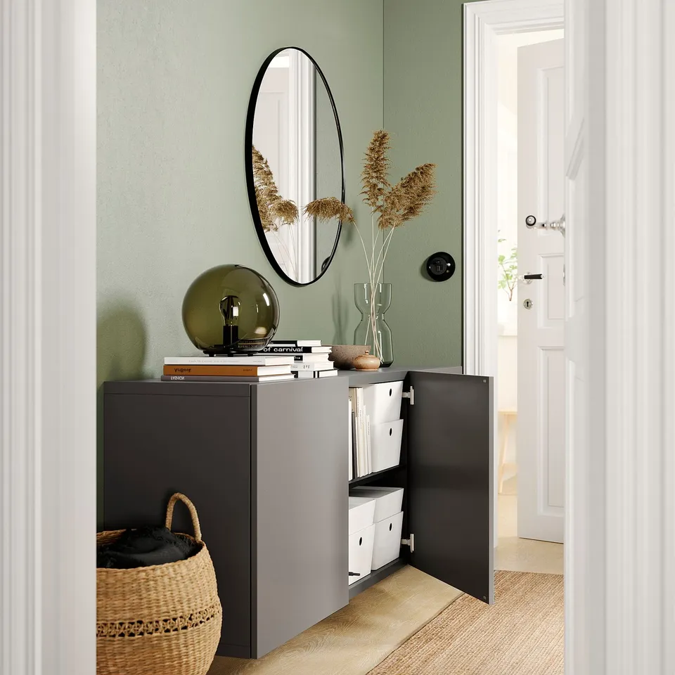 Modern room with BESTÅ black cabinet, green wall, and decor.