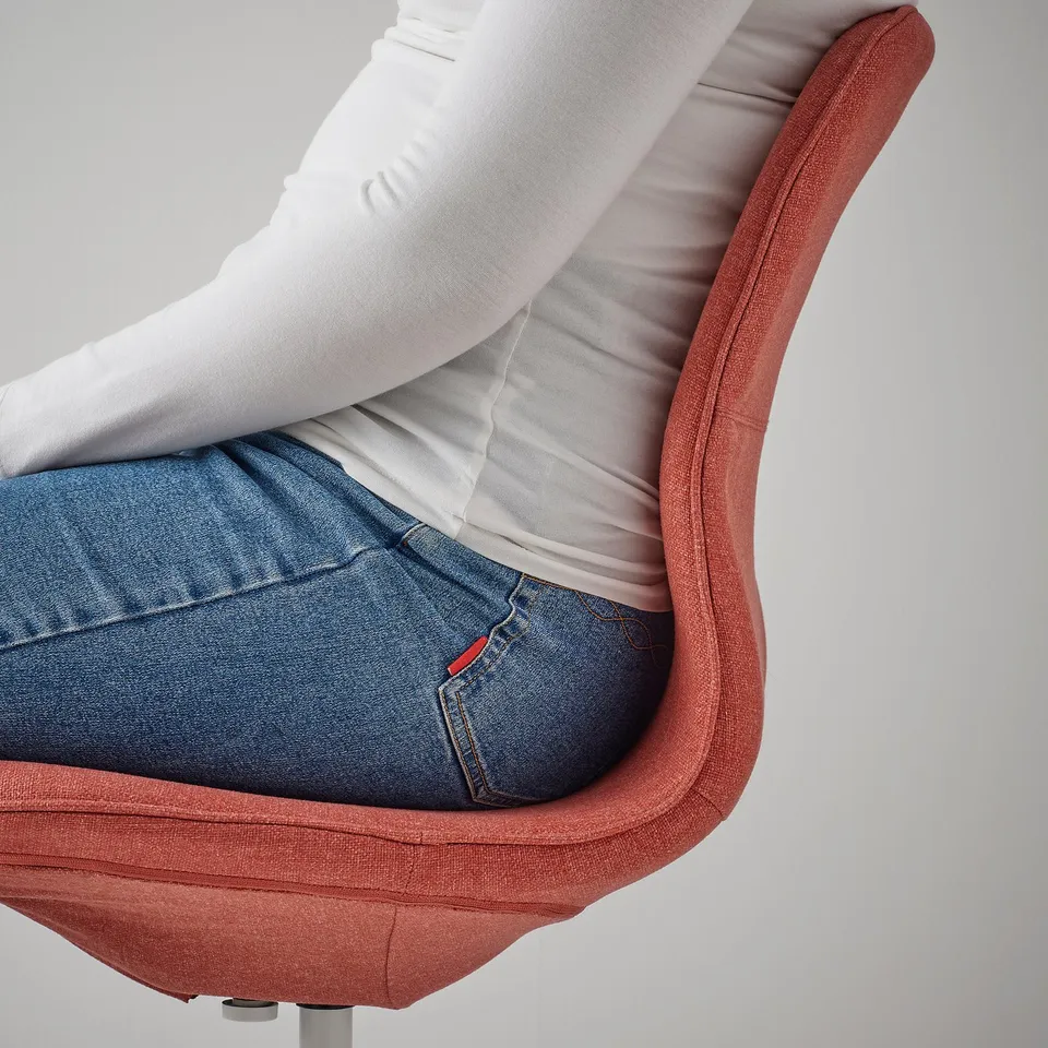 Person sitting in red office chair, leaning back with arms relaxed on armrests.