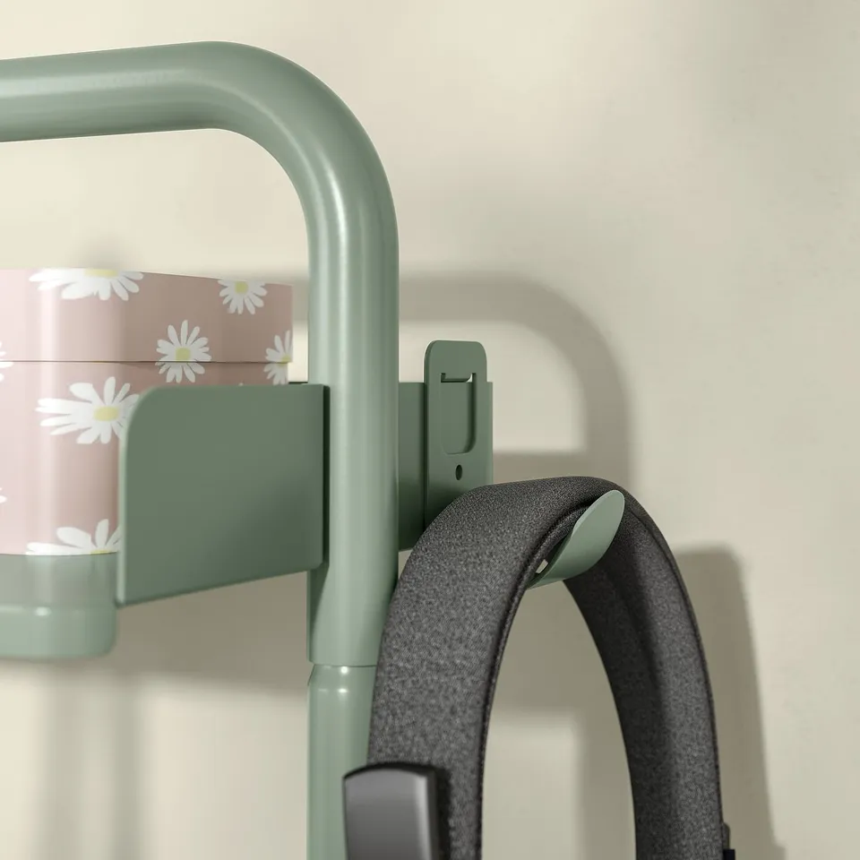 Green desk organiser with daisy canister and black headphones.