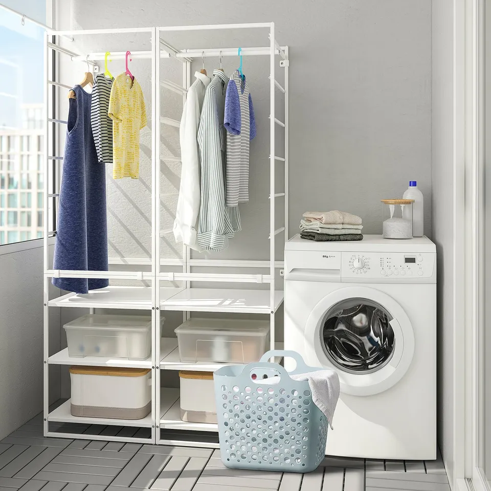 Laundry room with SLIBB basket holding clothes next to washing machine.
