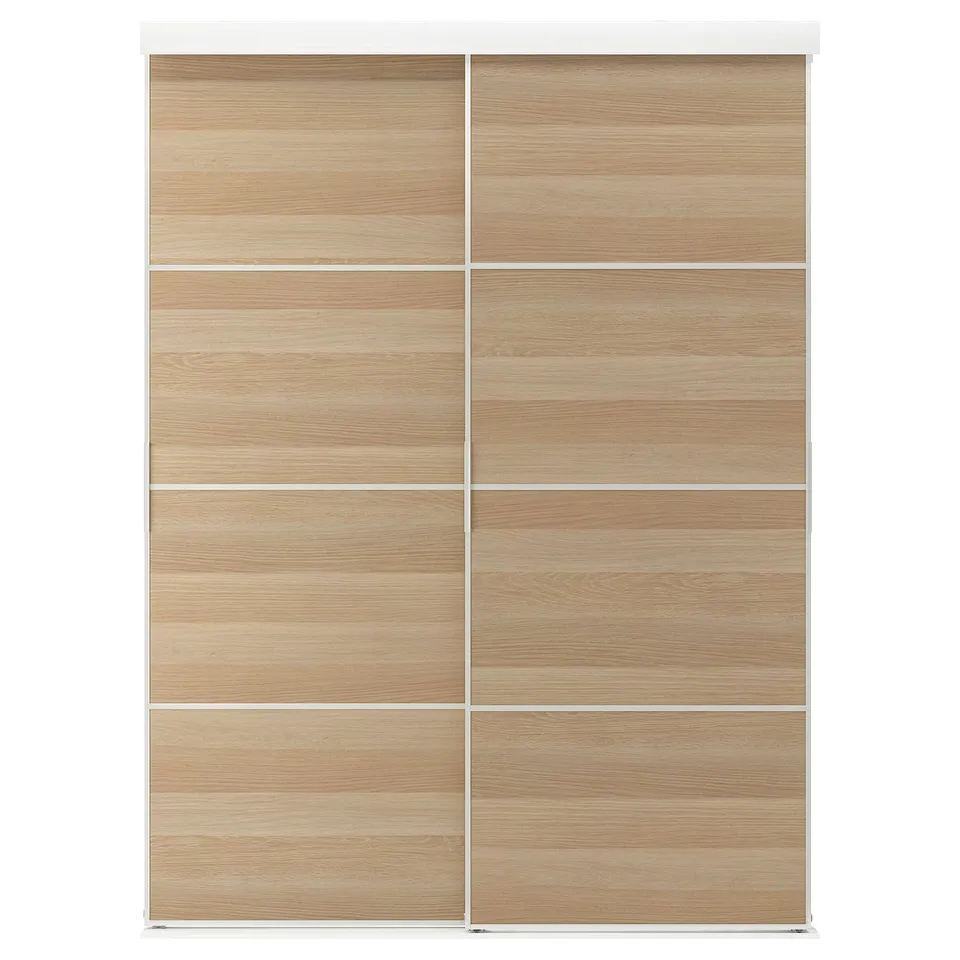 A SKYTTA light wooden wardrobe with sliding doors, framed in white.
