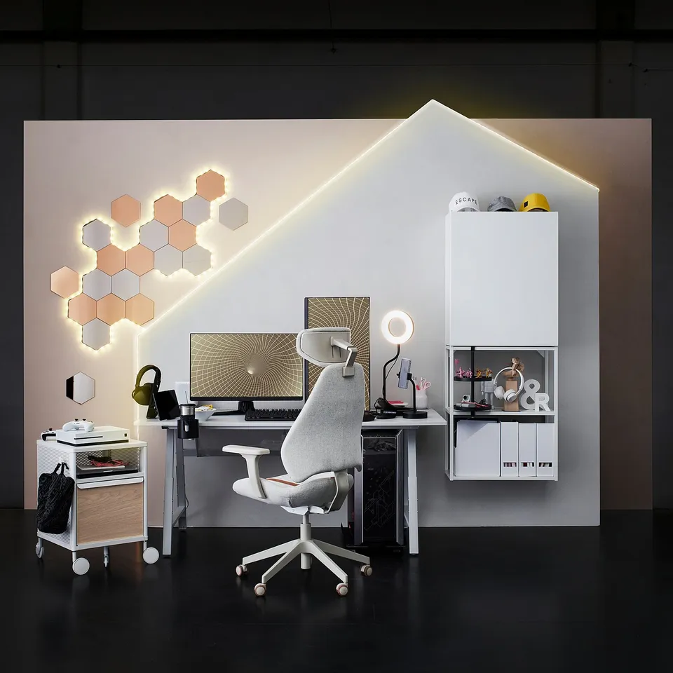 Modern home office setup with VATTENSTEN led light strips in white and hexagonal shapes, a white desk, grey office chair, and screen.