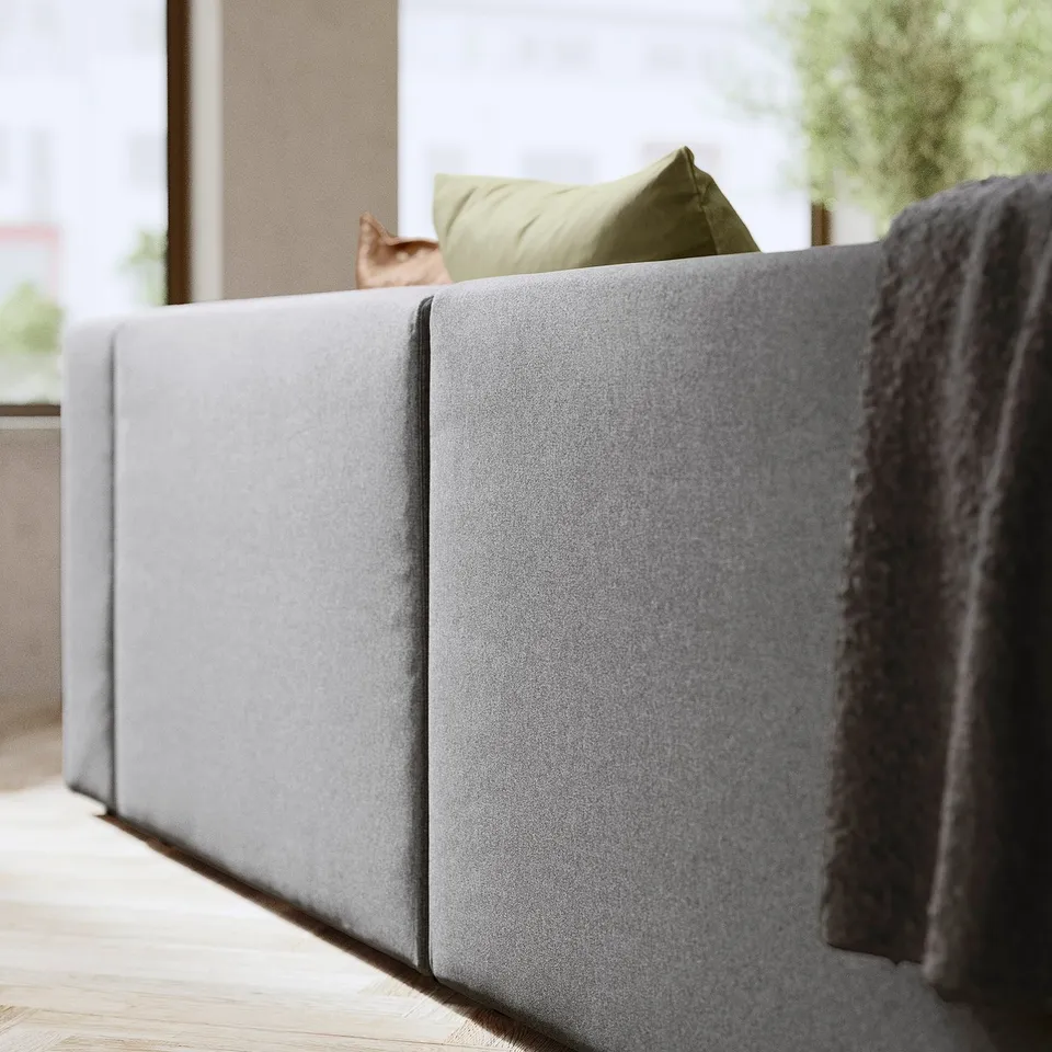 A cosy grey JÄTTEBO sofa in a modern living room with a cat and green pillows.