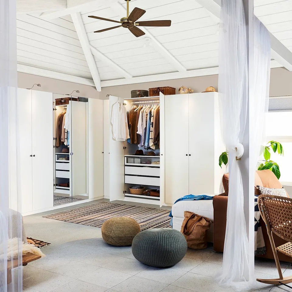 White bedroom with soundproofing, closet, and seating.