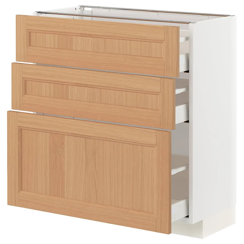 Displays a white METOD kitchen cabinet with oak drawers and doors. The cabinet three wooden drawers and two wooden doors, designed for storage.