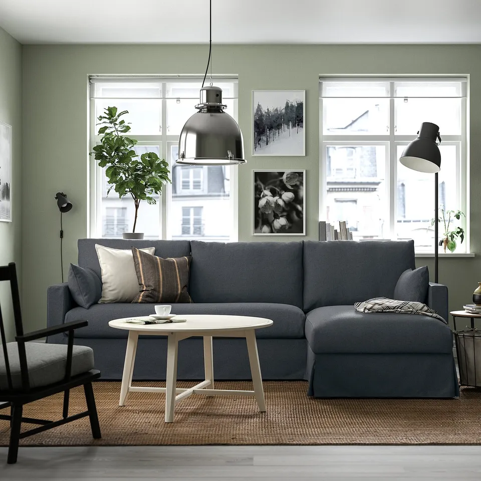 Modern living room with HYLTARP sectional sofa, cushions, lamp, armchair, and plant.