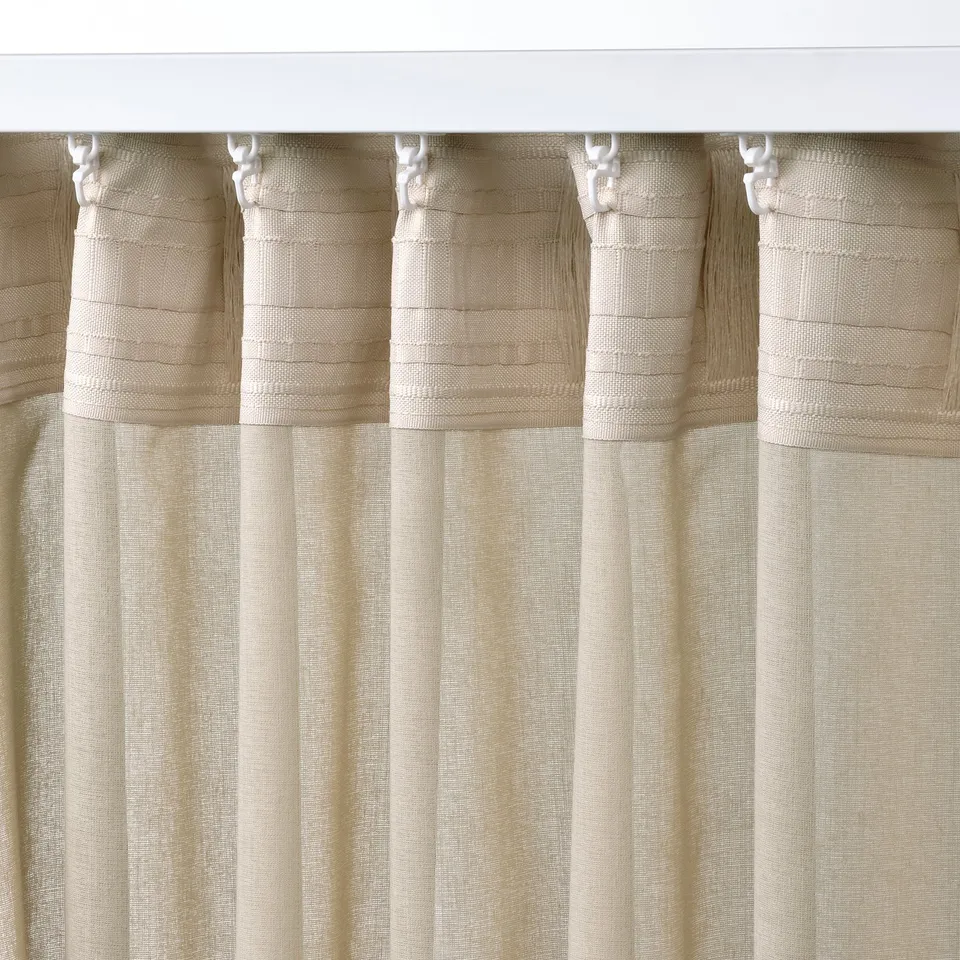 Beige sheer curtains with cord loops hanging uniformly, providing privacy while letting light through.