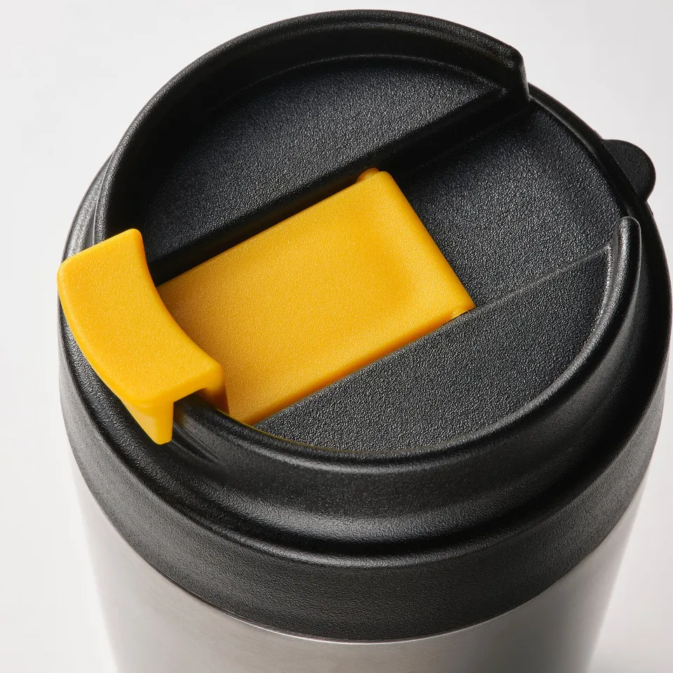 Black travel mug with yellow lid lever, durable and spill-proof design.