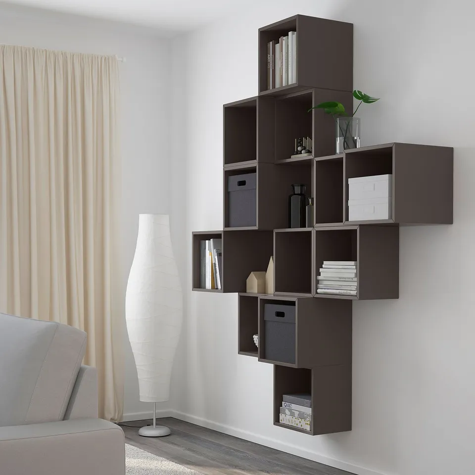 Modern living room with wall-mounted black modular storage holding books and decor.