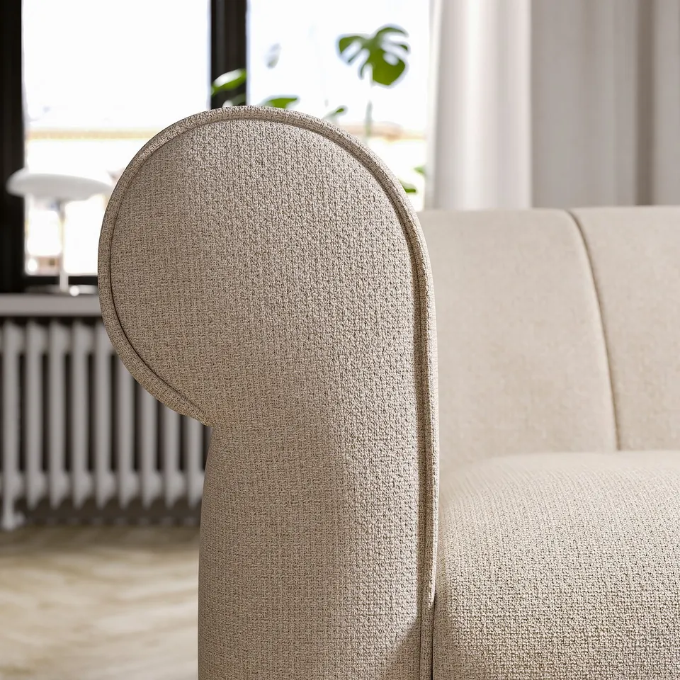 Modern armchair with rounded beige fabric design, soft cushions, and wooden legs.