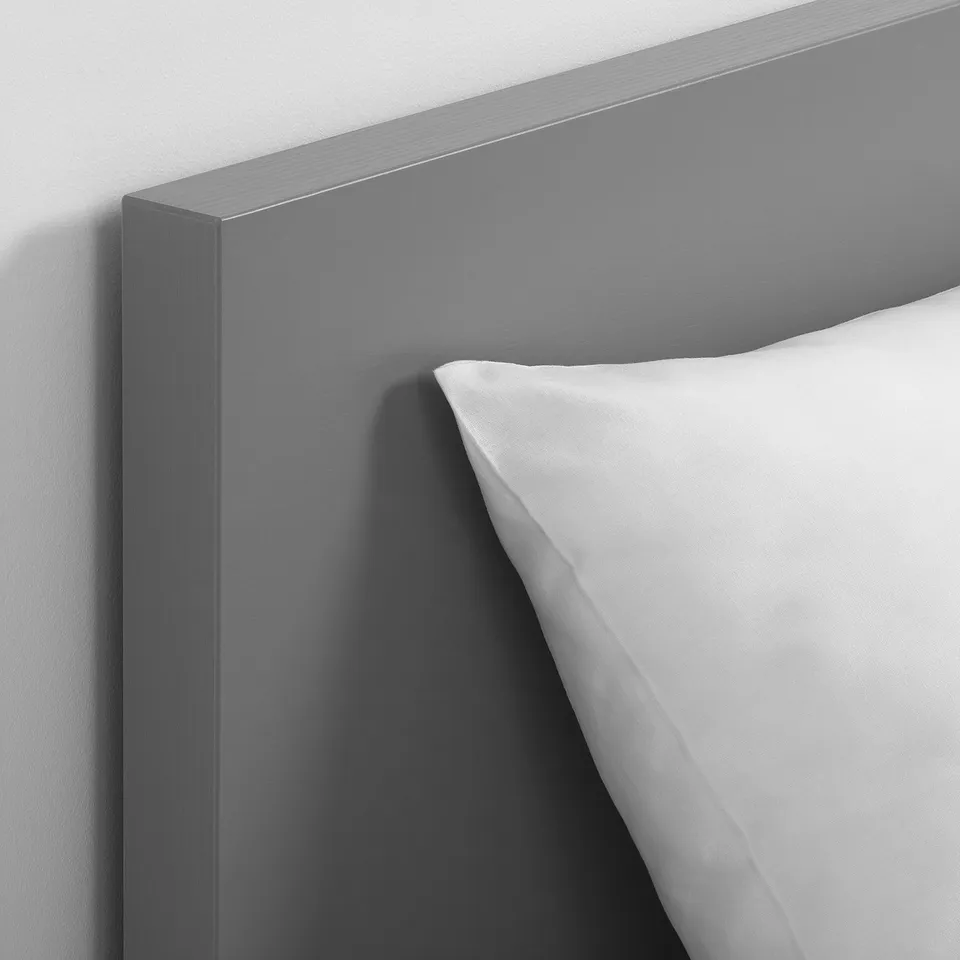 Close-up of grey headboard with a white pillow, showcasing smooth finish and seamless corner joint.