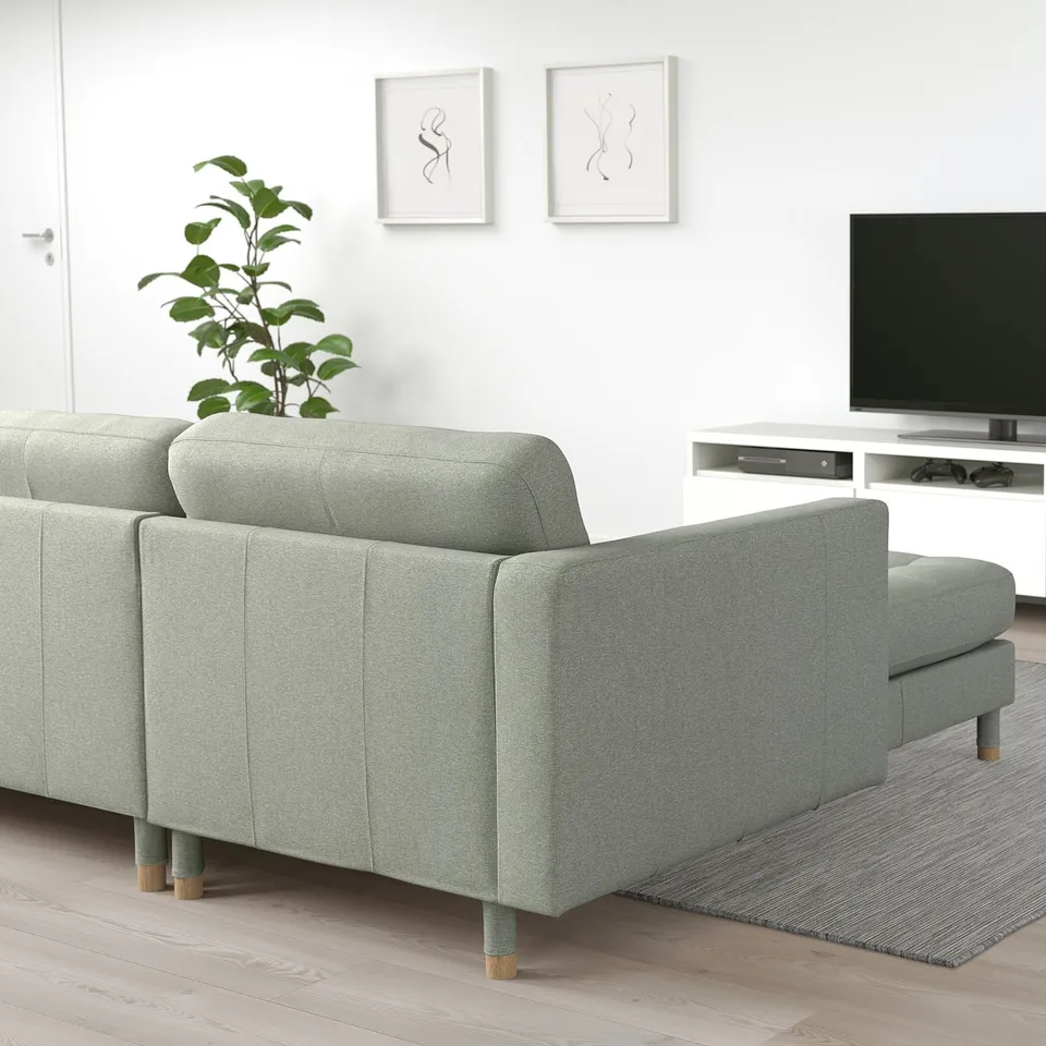 Modern grey LANDSKRONA sofa in minimalist living room with plant.