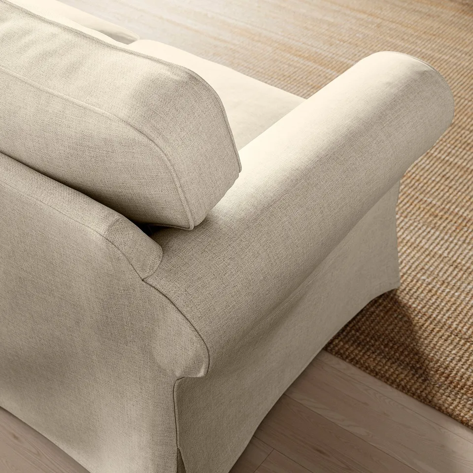 Closeup of plush, beige EKTORP sofa armrest, showcasing soft, textured fabric and comfortable cushioning.