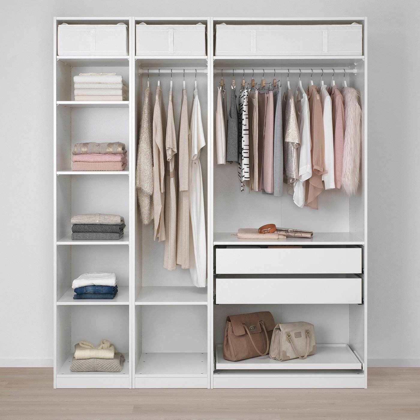Organised closet with white shelves. Clothes hang on rods and fold on shelves. Bottom shelves hold bags and baskets. Basic storage setup.