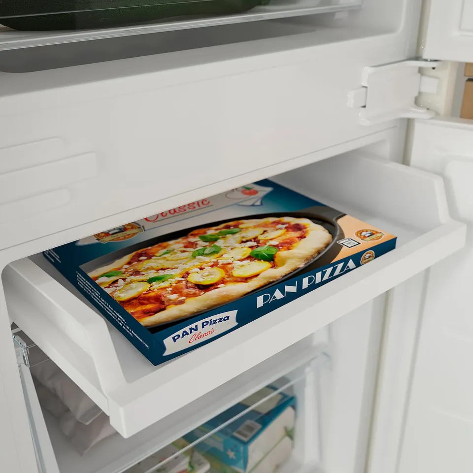 It shows a frozen pizza box inside a white refrigerator drawer.