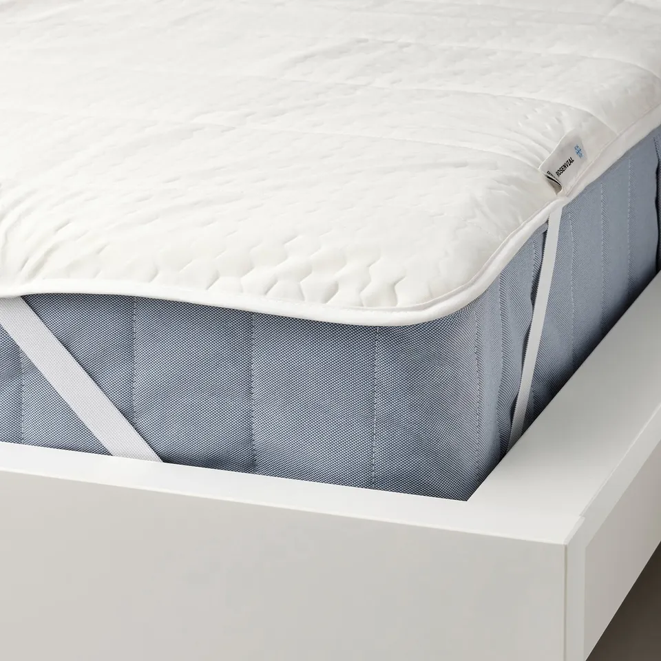 White mattress protector with elastic corners on blue mattress.