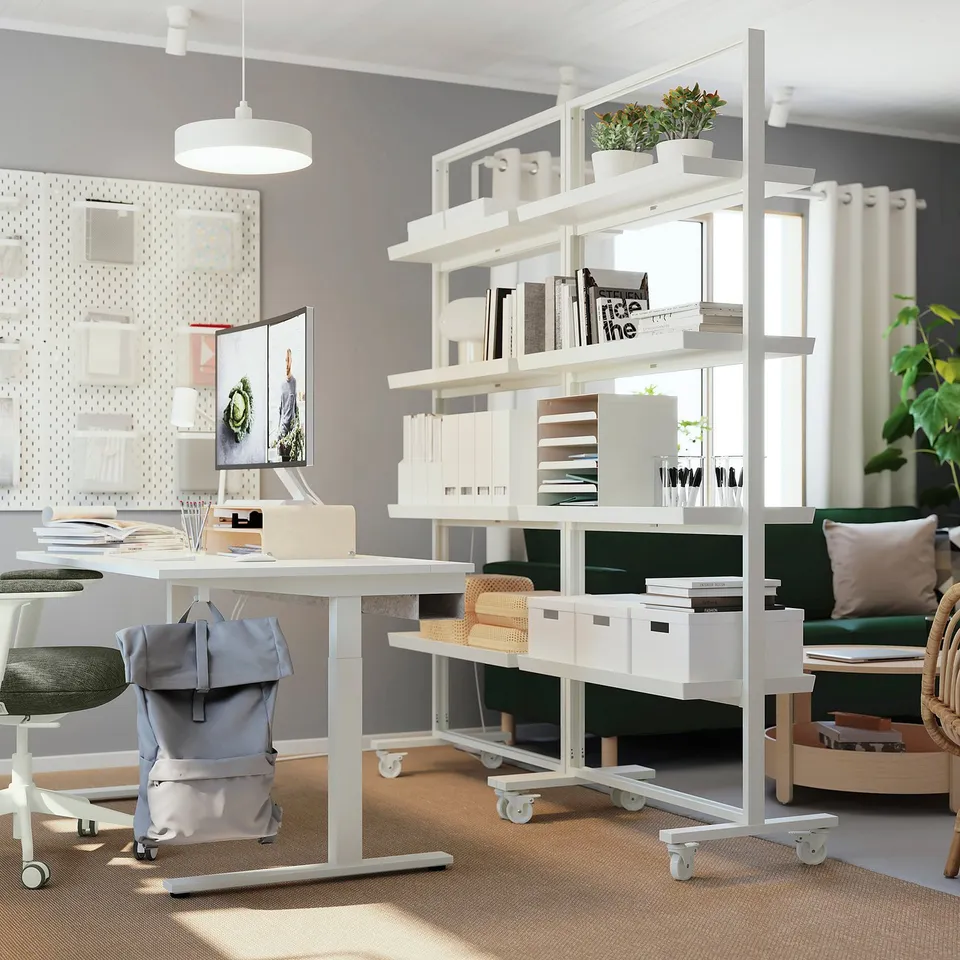 Modern office space: adjustable, mobile shelving divides area, displays books, plants, and decor, with integrated lighting.
