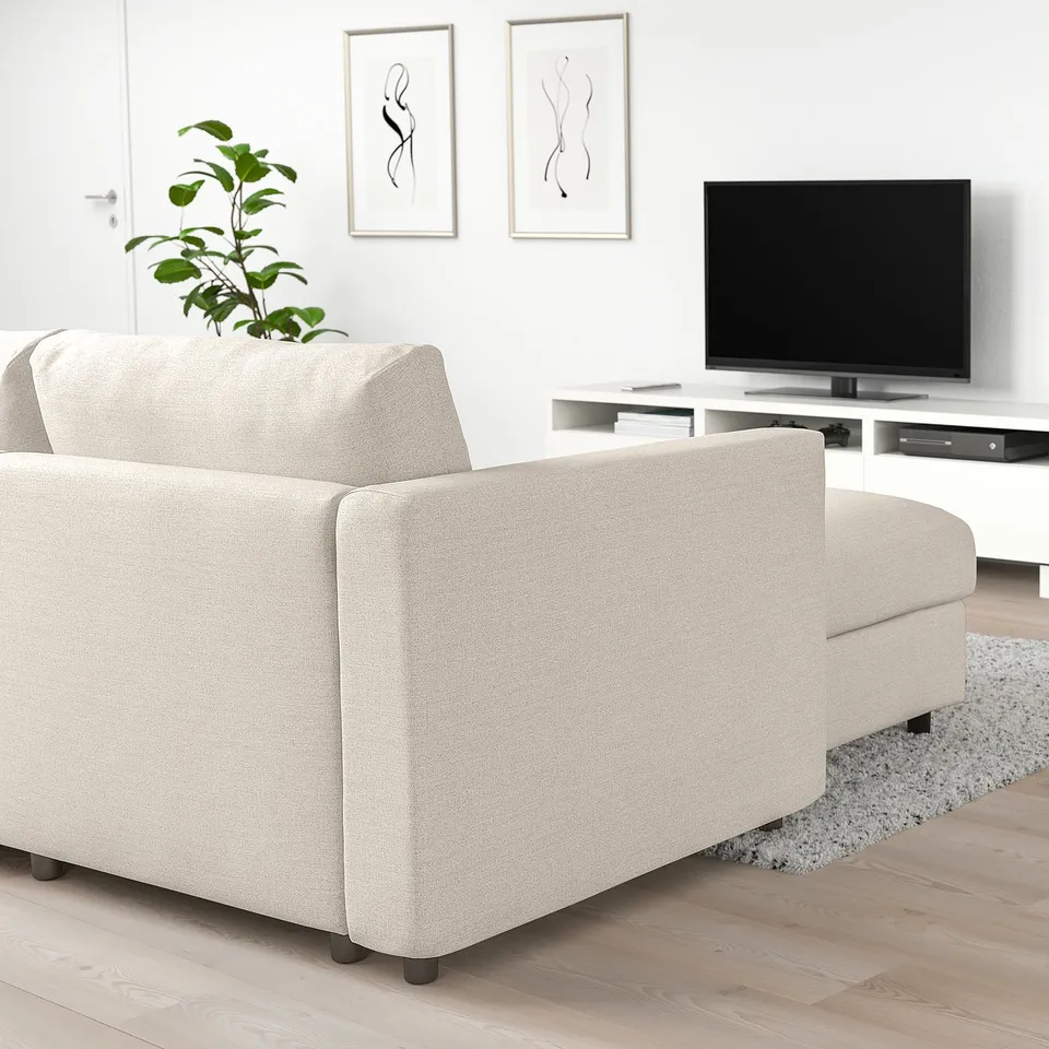 Modern living room with light beige VIMLE sofa-bed, plant, tv, and art.