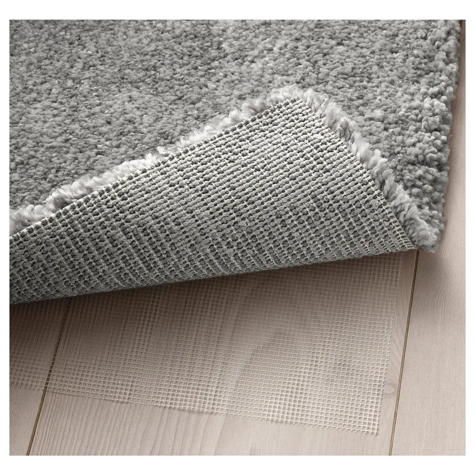 A cosy, thick rug with a soft, shimmering pile. The textured underside shows its non-slip feature.