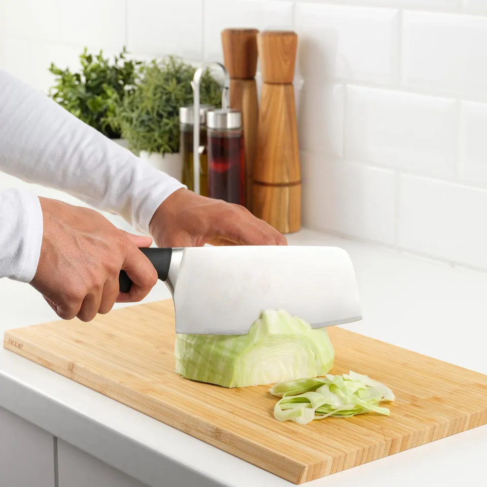 Person slicing cabbage with VÖRDA knife on cutting board. The knife remains sharp due to molybdenum stainless steel.