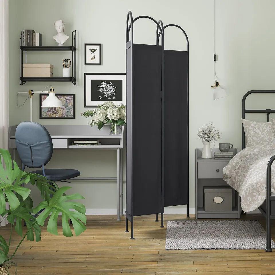 Modern bedroom with GRÅFJÄLLET black room divider; desk, chair, bed, plants, art, and decor.