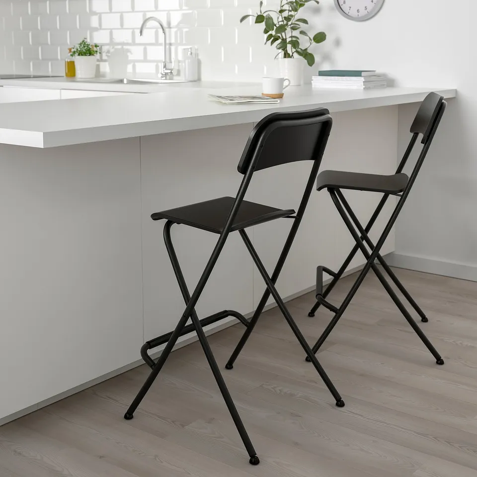 Two black FRANKLIN stools at kitchen counter, sleek design, under-counter fit.