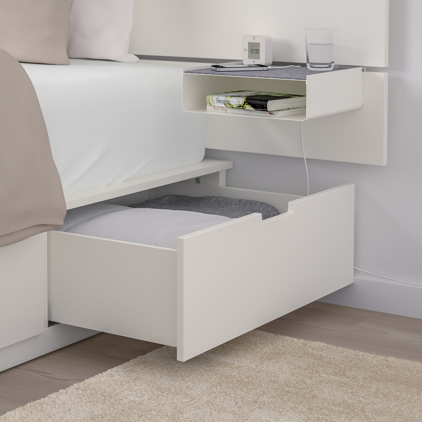 Modern white bed frame with large storage drawers, a built-in shelf, and a headboard box for easy access and organisation.