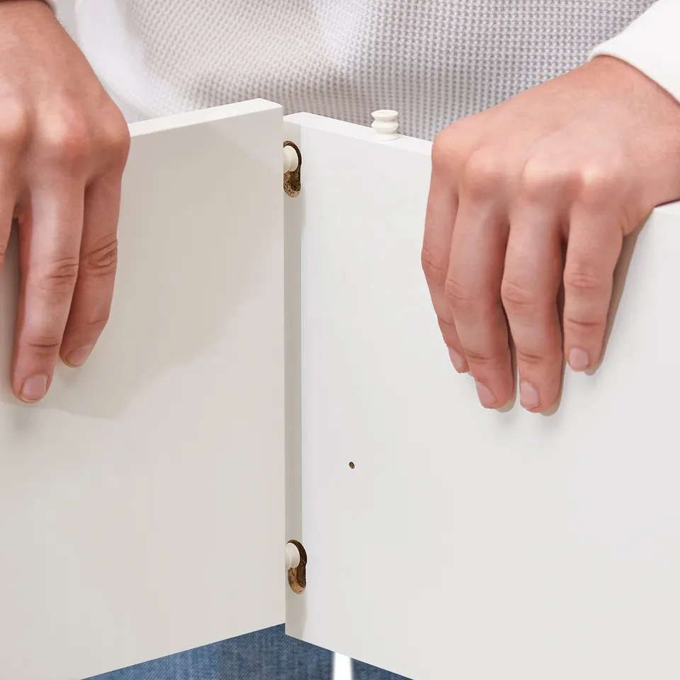 A person opening white VIHALS cabinet, showing its organised storage design.