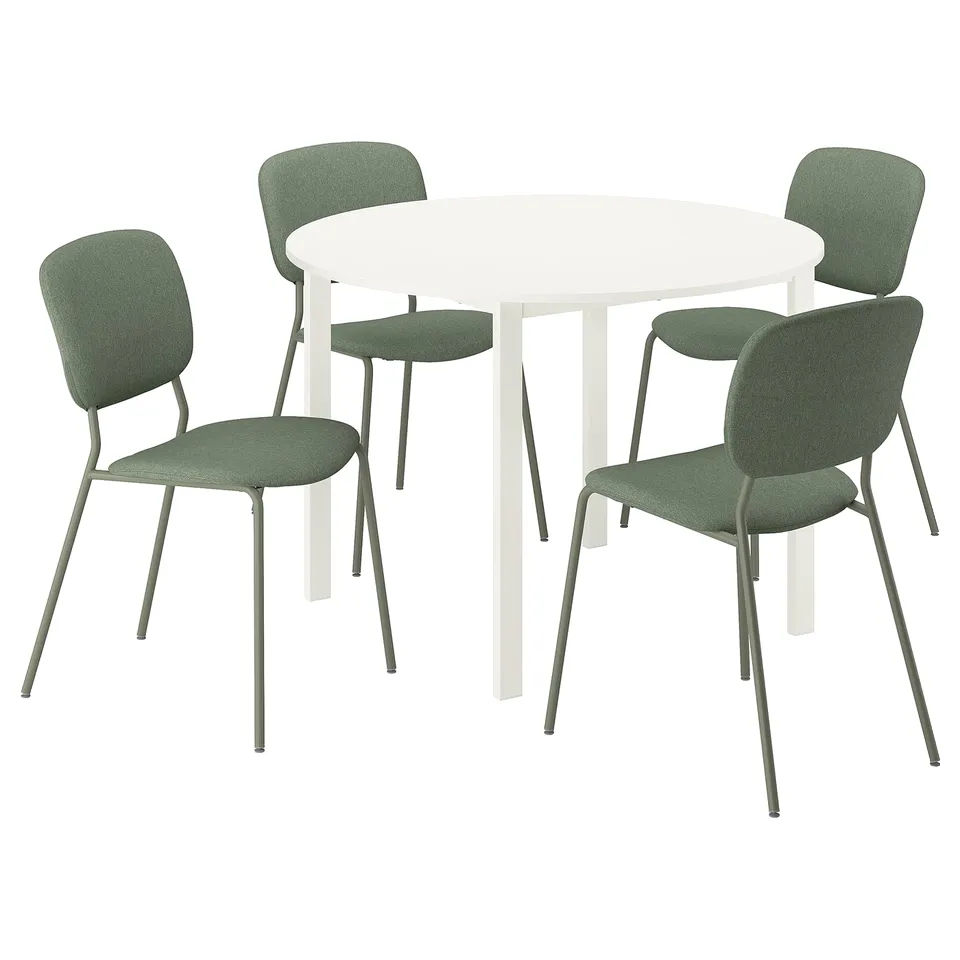 Modern dining set with 4 green fabric chairs around a white round table. Sleek, minimalist design.