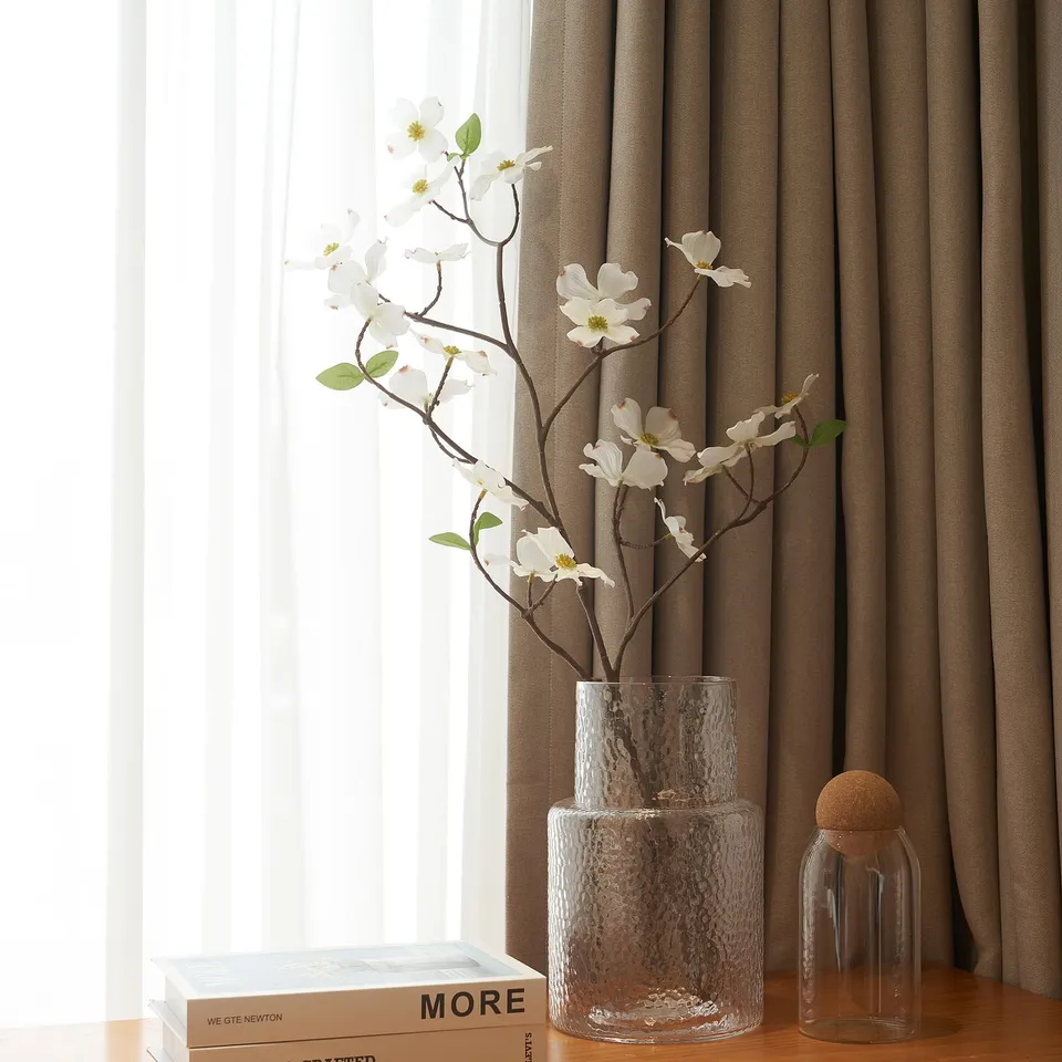 Glass vase with white flowers on table. Indoor/outdoor.