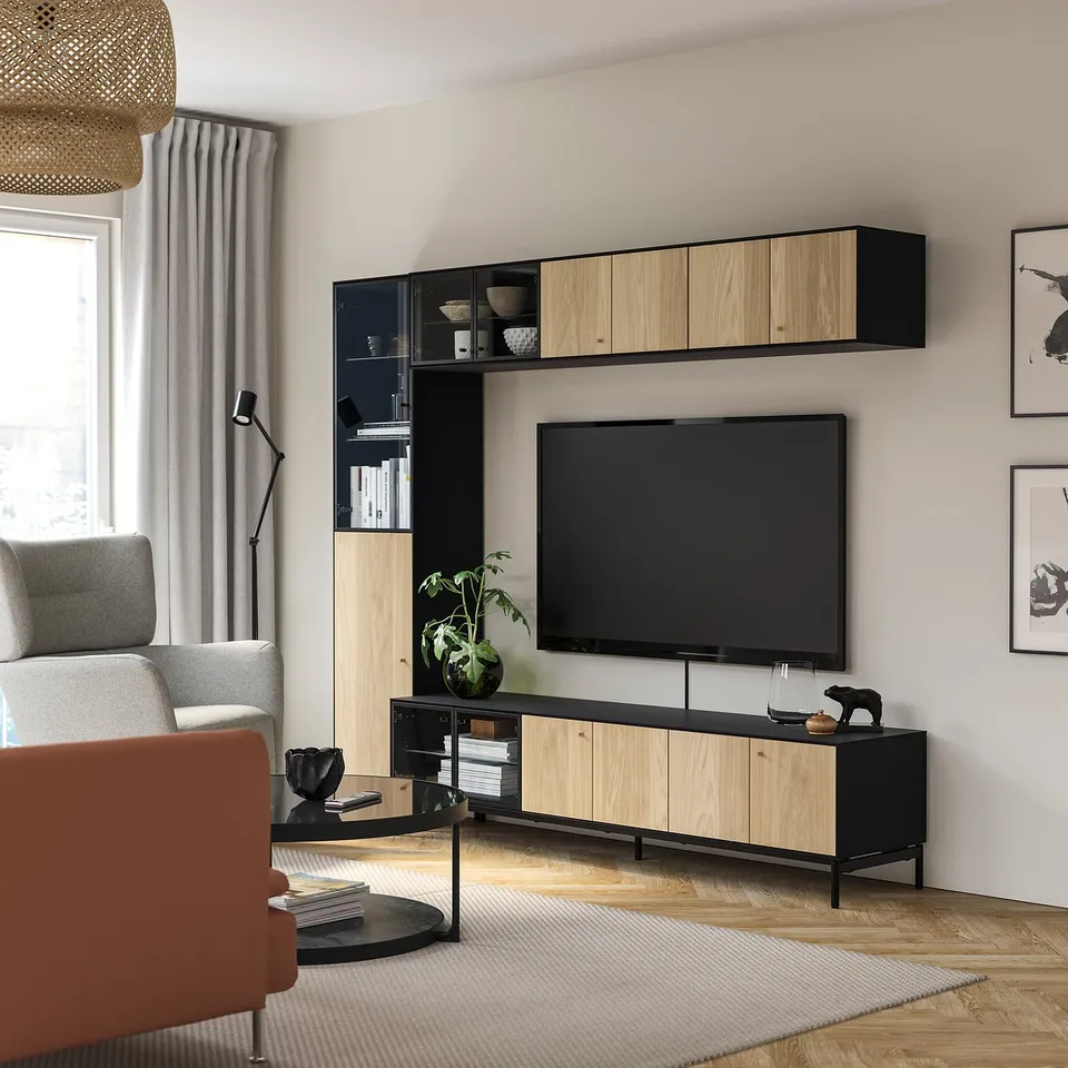 Modern living room with BOASTAD storage in black & oak, tv, sofa, and orange chair.