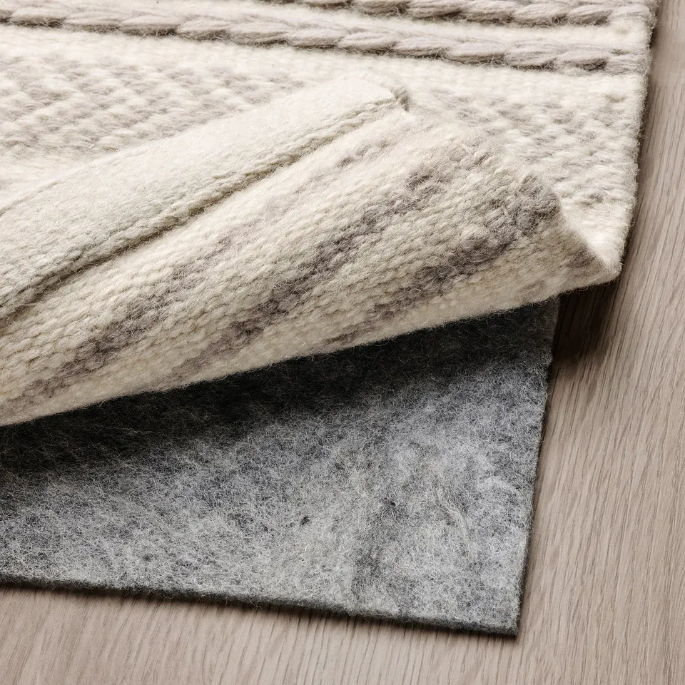 Rug with anti-slip felt underlay. Easy chair movement, durable wool. Neutral grey and cream.