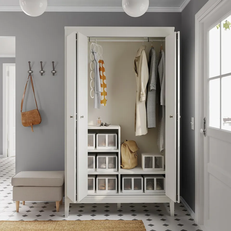 White IDANÄS wardrobe with bifold doors, grey interior, and organised storage in a grey room.