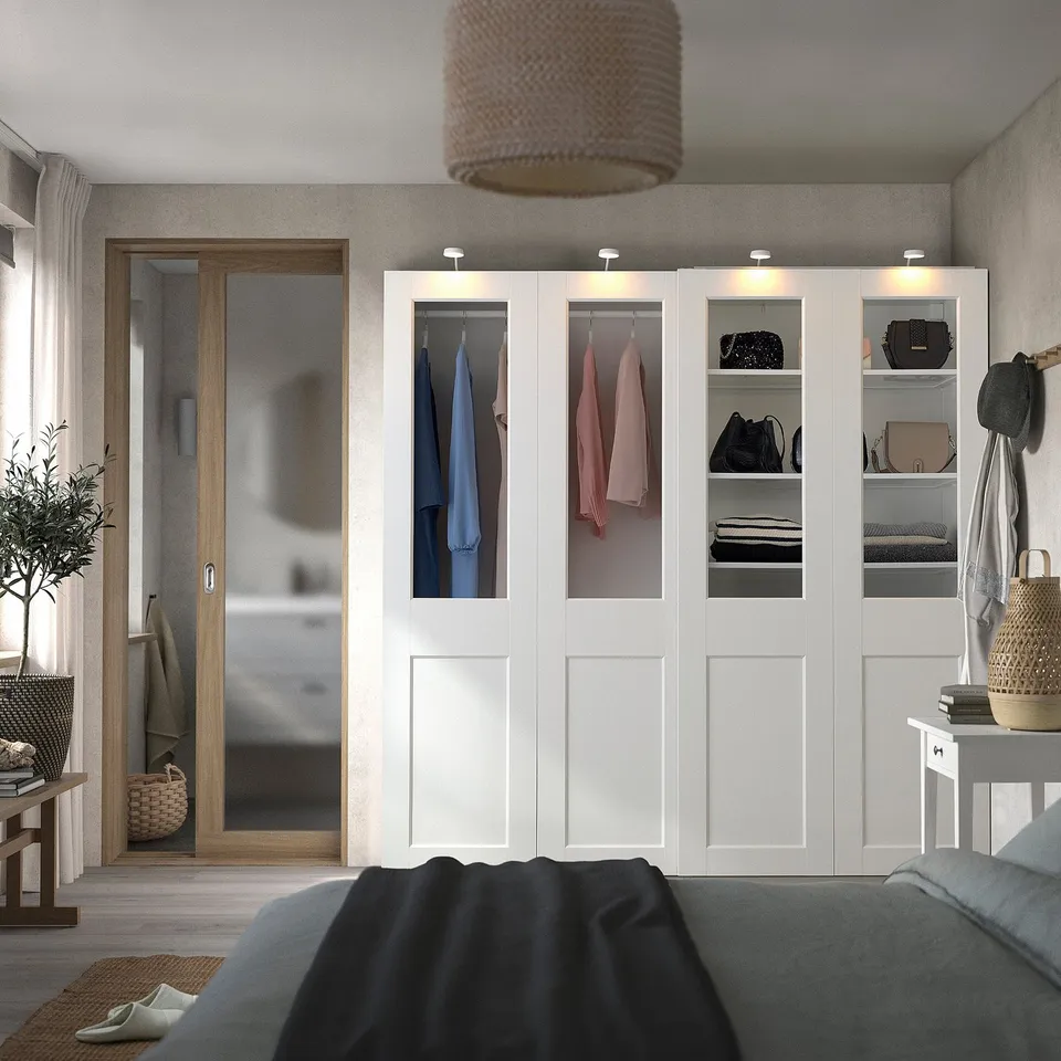Modern bedroom with PAX wardrobe, bed, and bags.