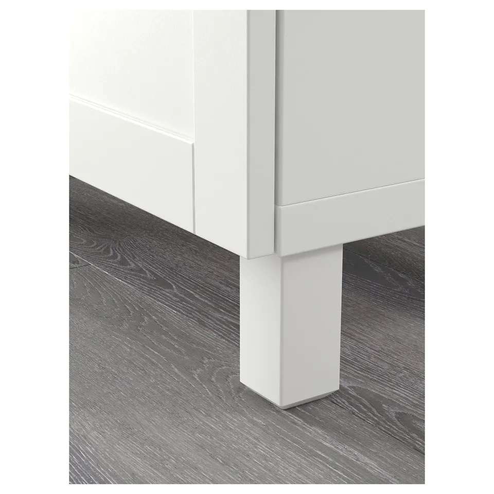 Modern white cabinet with soft-close feature on dark wood floor.