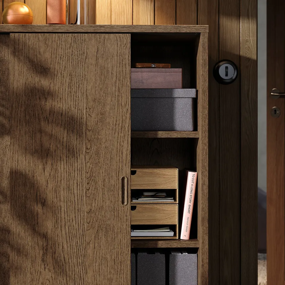 Wooden storage unit with sliding doors and shelves displaying books and boxes.