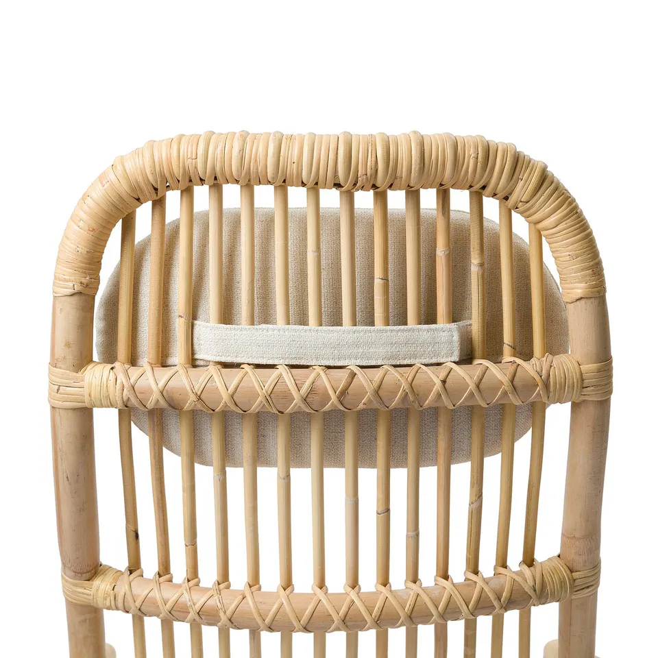 Wicker chair with curved back and armrests, featuring a cushioned seat and back for comfort.