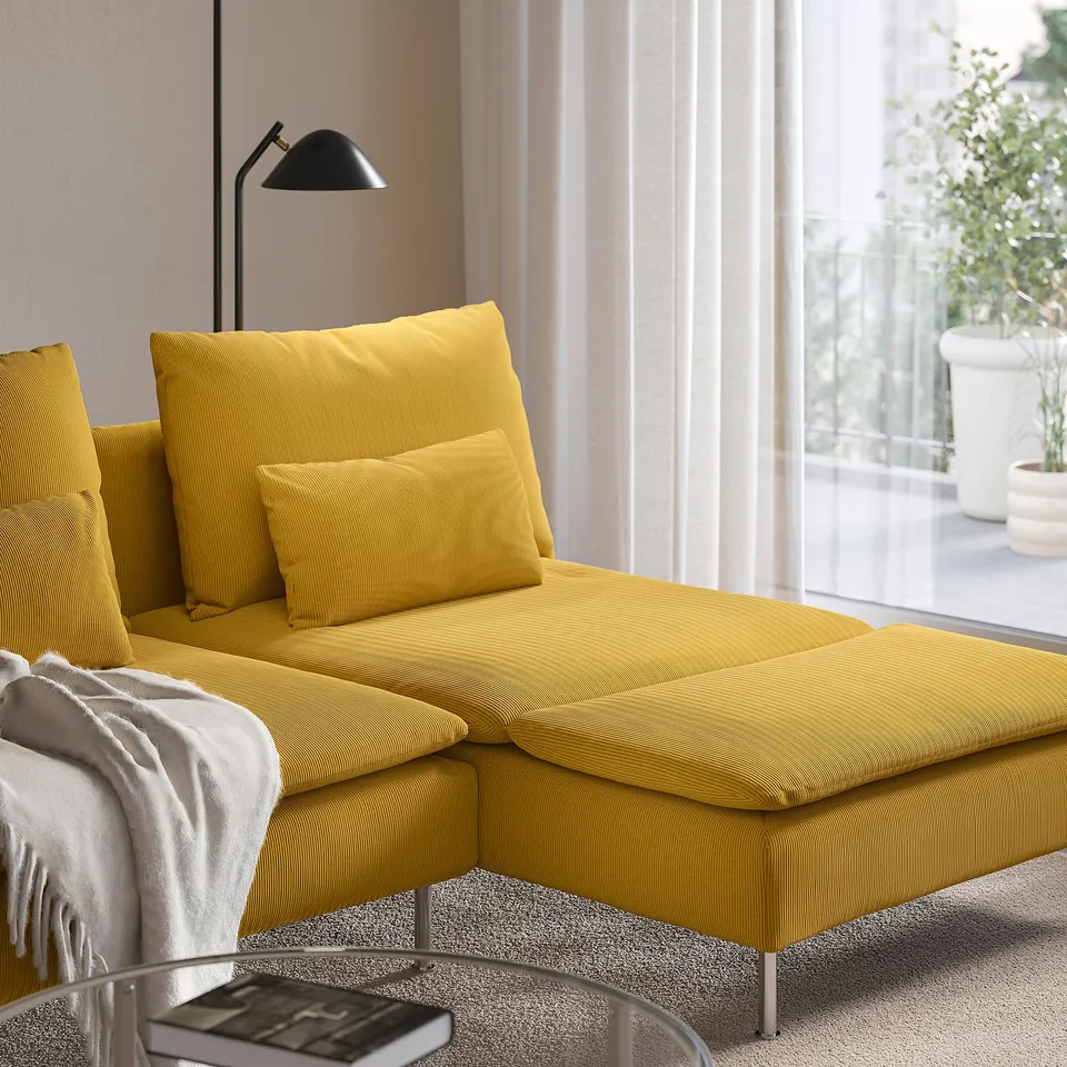 Mustard yellow sectional sofa by window with lamp.