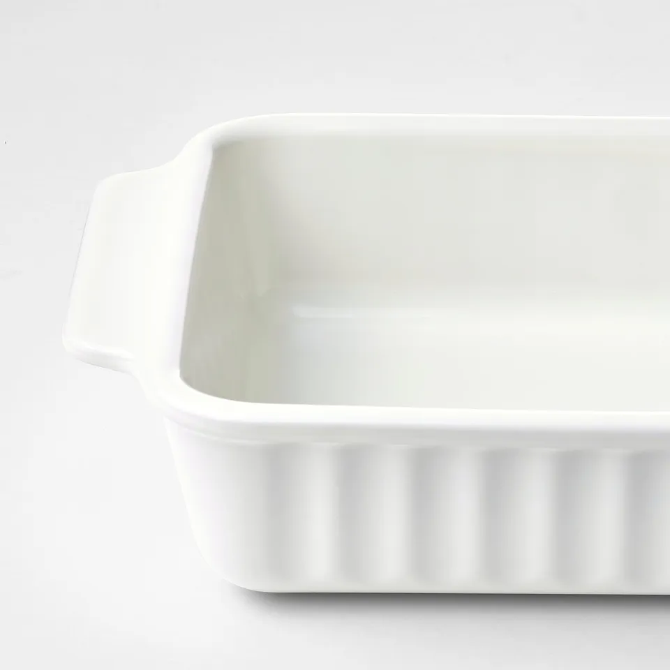 White oblong baking dish, sleek and clean. Sturdy handles, ribbed base, ideal for roasting.