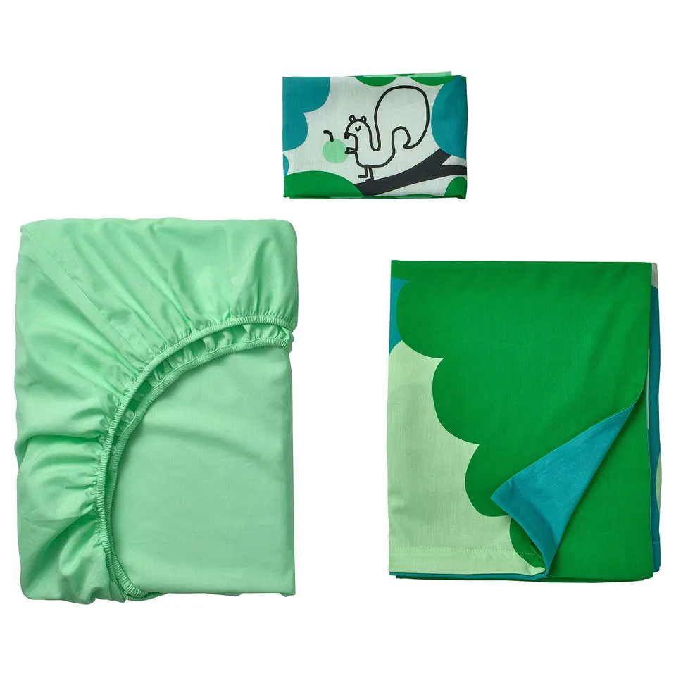 Baby bedding set: green fitted sheet, green & blue blanket with giraffe print, folded neatly.