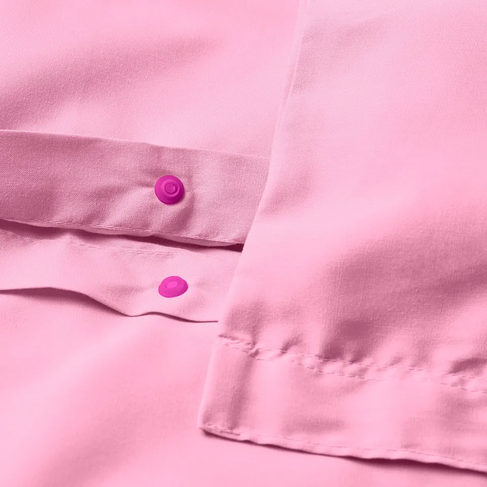 Close-up of pink duvet cover with visible pop-button closure, smooth fabric visible.