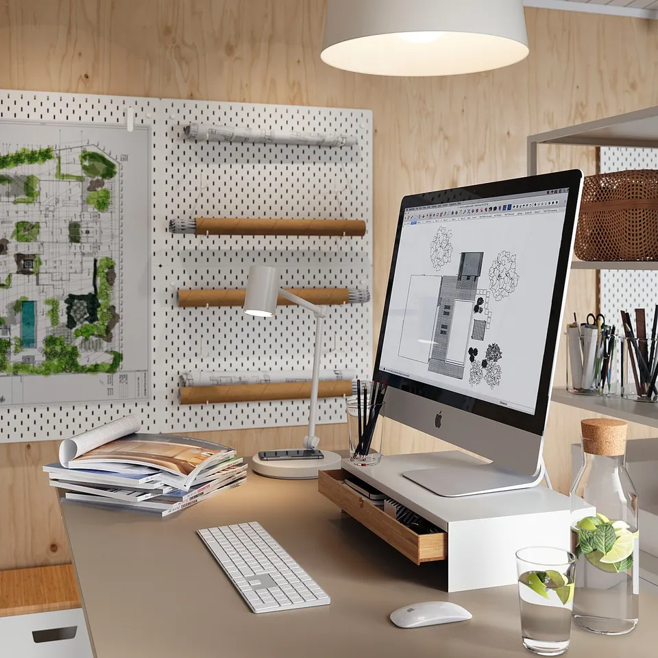 Home office with wooden walls, white desk, black computer, white lamp, and green plants.