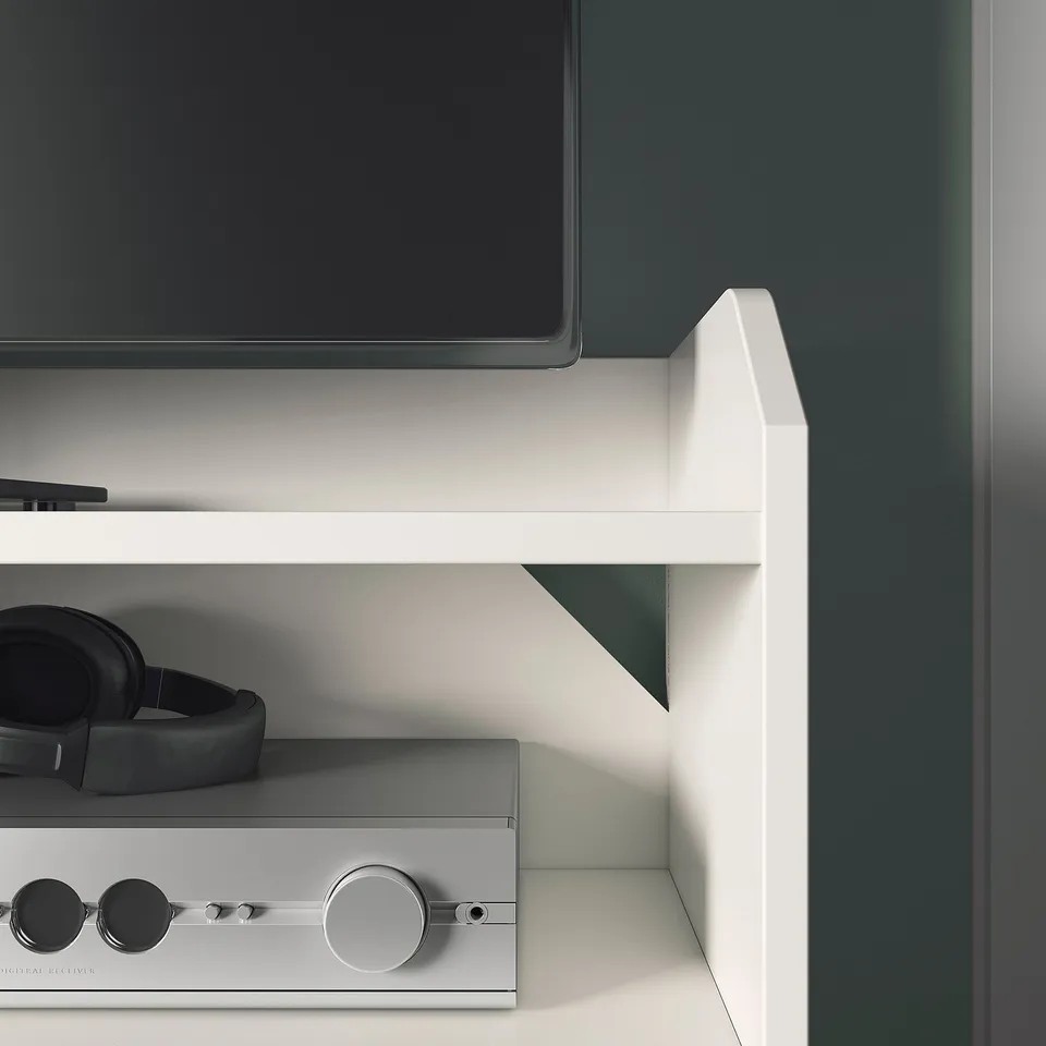 Modern media setup with white tv stand. Headphones, soundbar, and flat screen tv neatly arranged. Quality design and organisation.