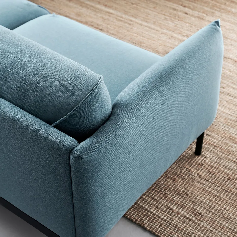 Light blue modern sofa, sleek design with smooth fabric, black legs.