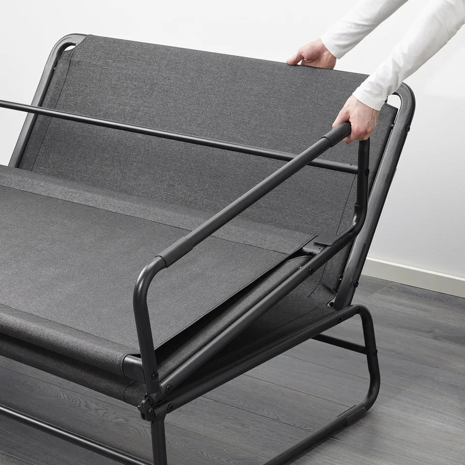 Image shows person adjusting HAMMARN sofa bed, demonstrating its quick transformation into a spacious bed.
